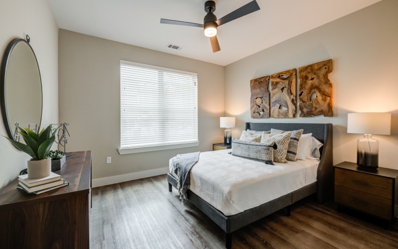 natural light pours through large window in bedroom with ceiling fan