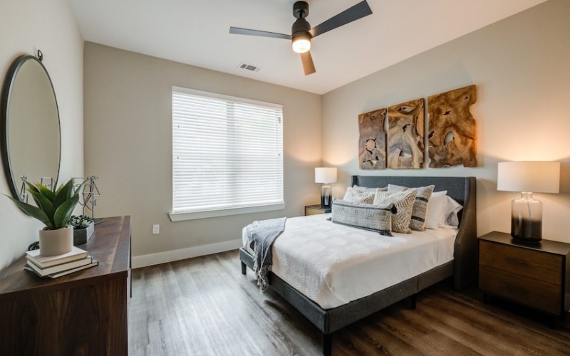 natural light pours through large window in bedroom with ceiling fan