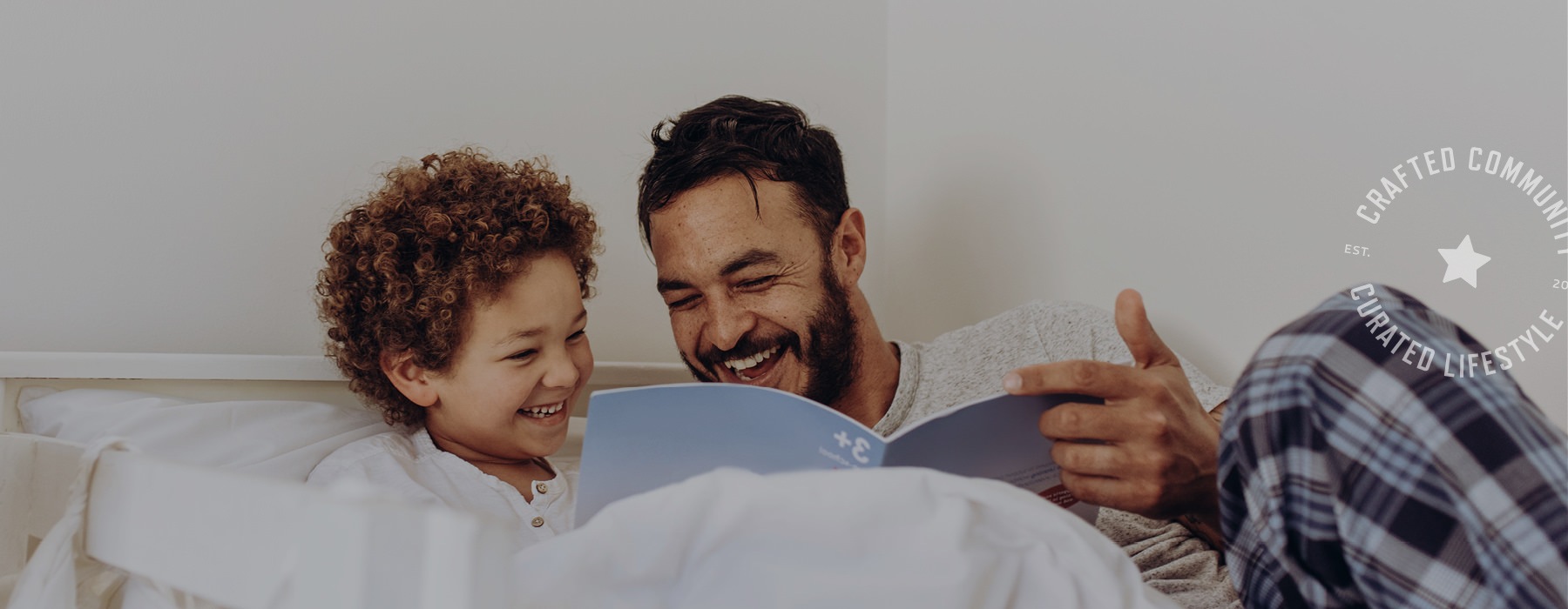 father and son read together in bed