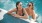 two women laugh together in pool